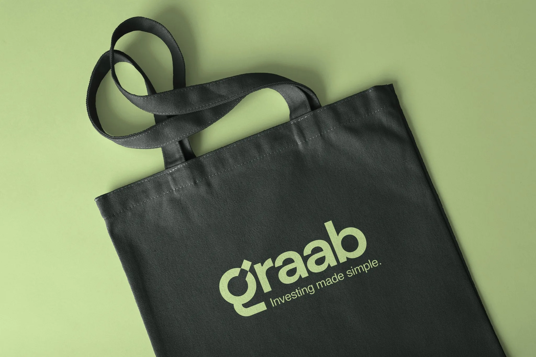 Black Graab tote bag with the Graab logo on a light green background